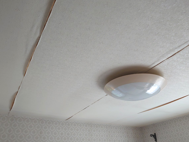 雨漏りで天井のクロスが剥がれてきた様子