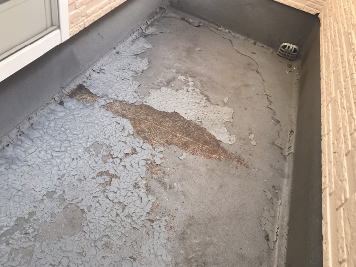 防水層が劣化し、下地が見えている状態のベランダ