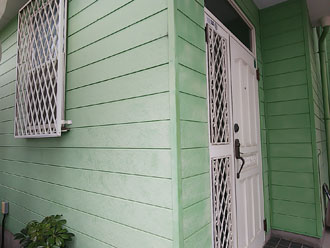 色褪せてきたミントグリーン色の窯業系サイディング外壁　玄関周り
