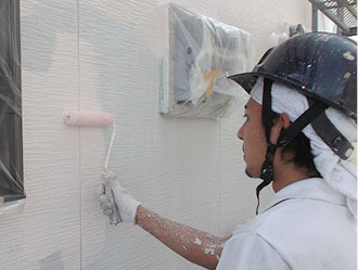 外壁に塗装を施している作業員